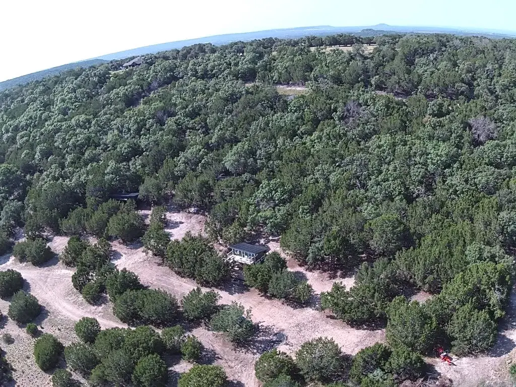 Aerial view of the wooded property with two casitas among the trees