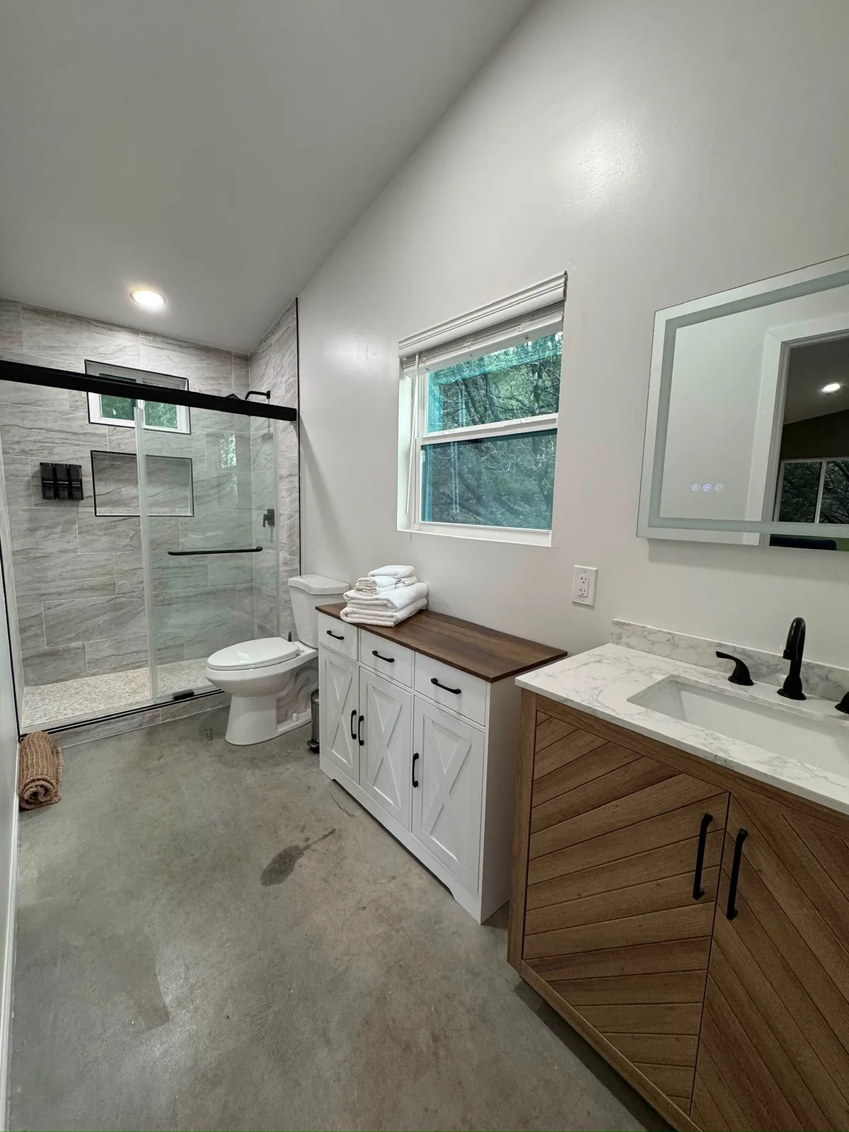 The bathroom, with a walk-in shower and a wood vanity