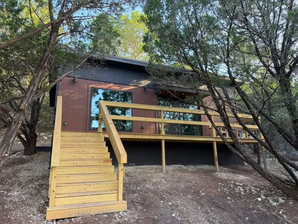 Casita 2 with its wide deck and tall windows facing the trees