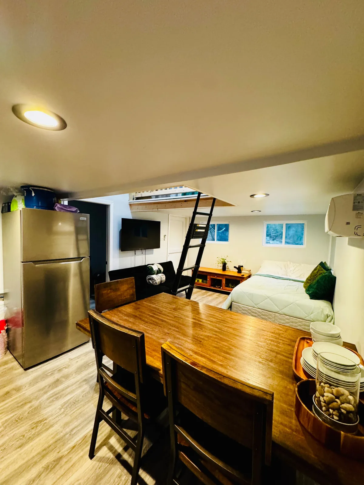 The open living space — dining table, bed and the ladder up to the loft