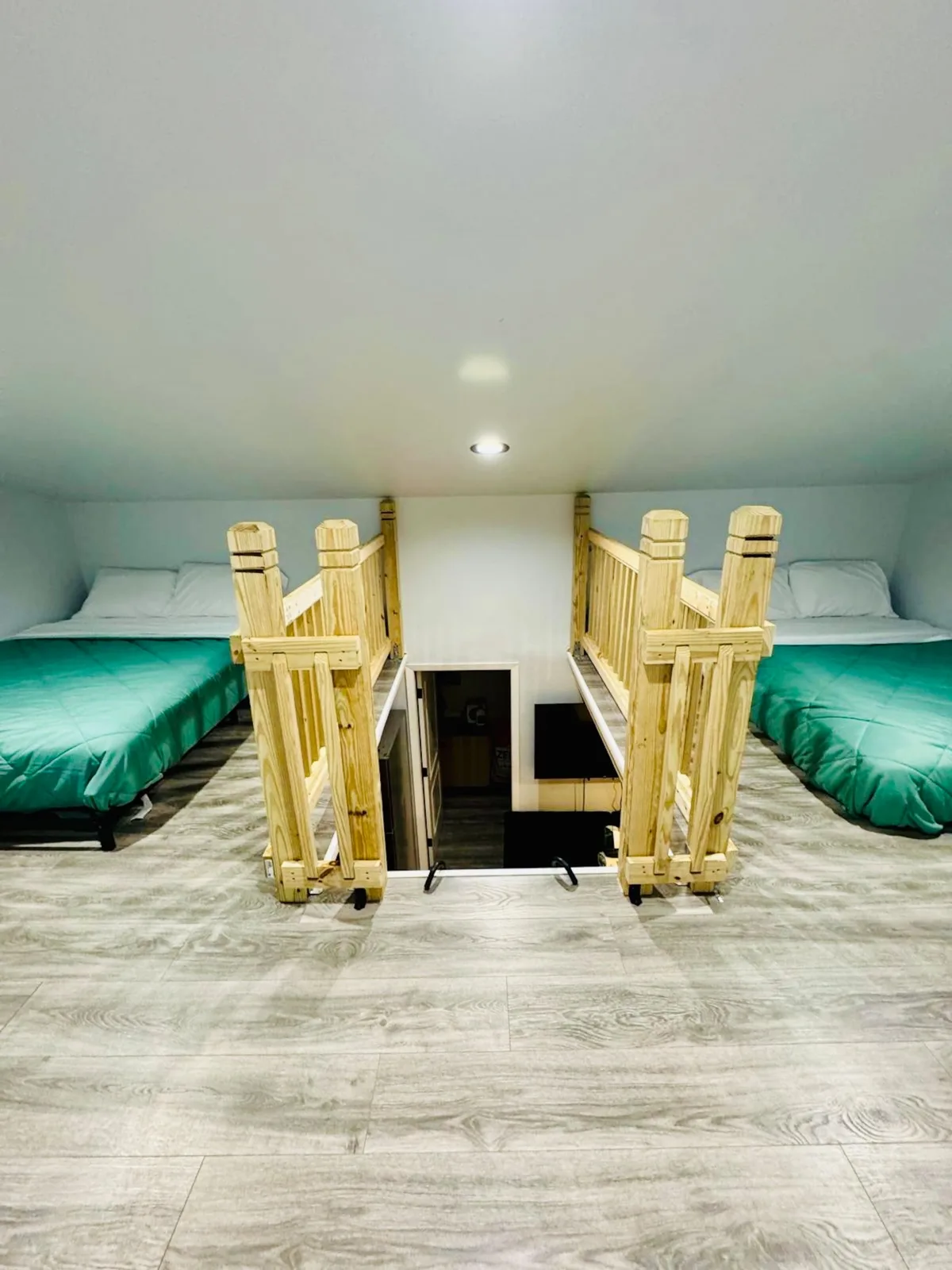 The sleeping loft, with a bed on each side of the stairwell railing