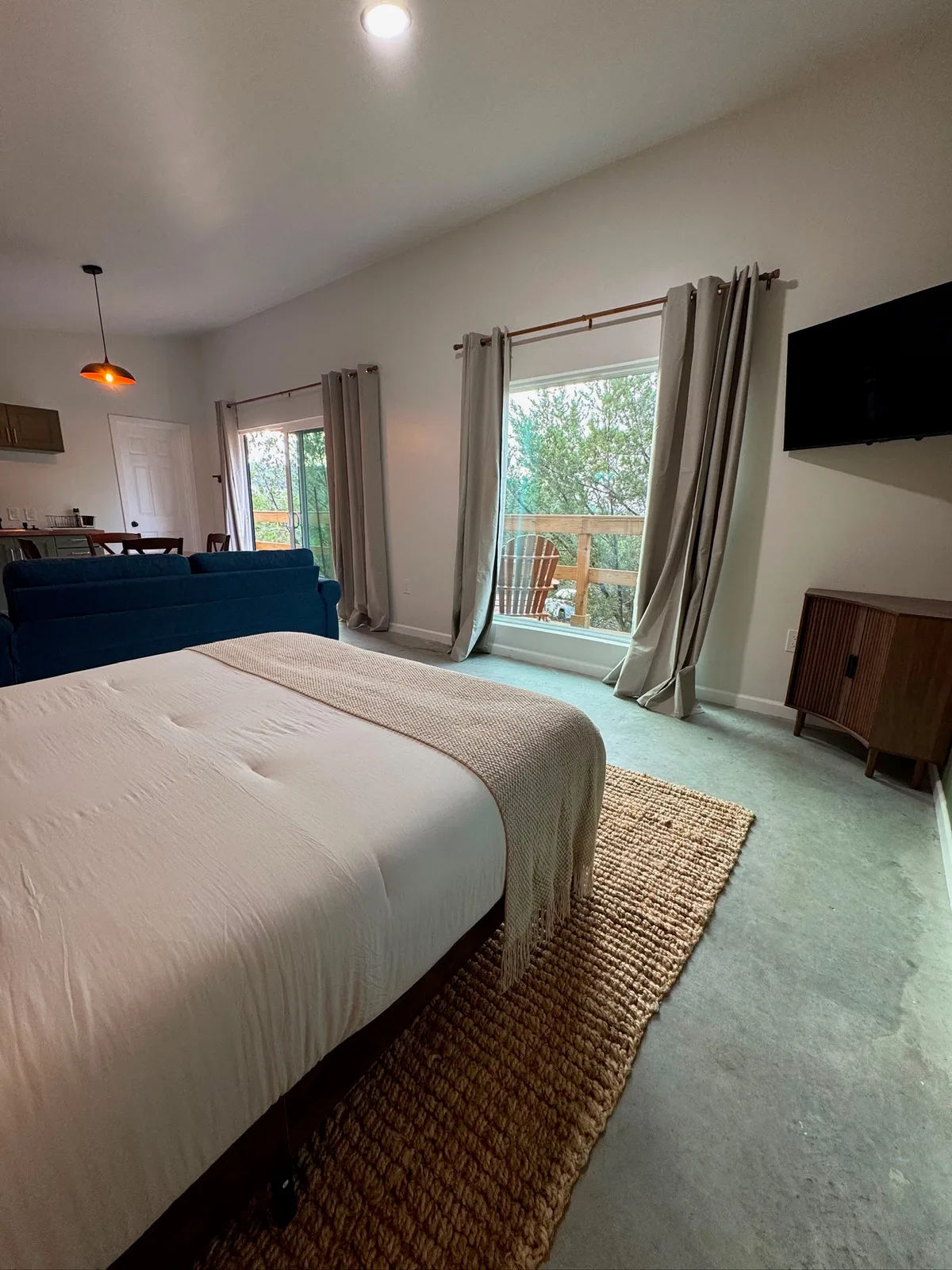 The bed and sofa beside the sliding door out to the deck