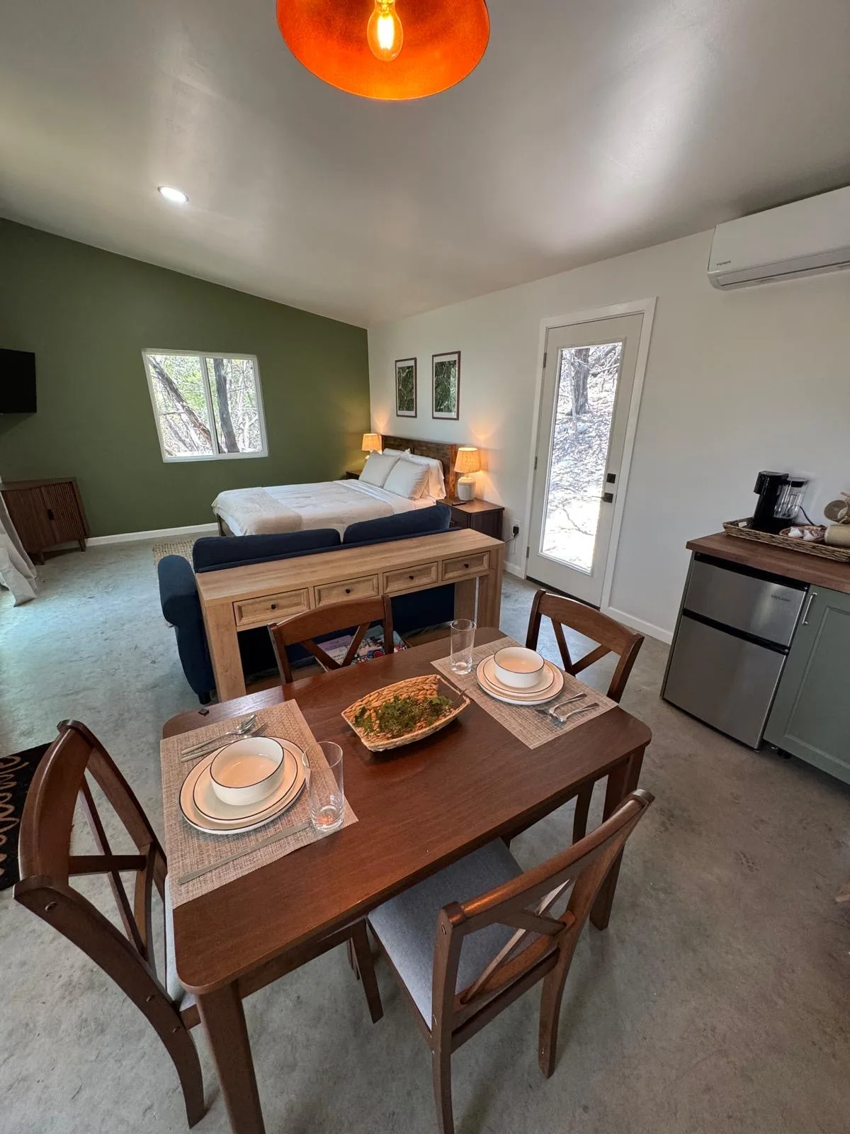 The dining table set for four, with the kitchenette behind