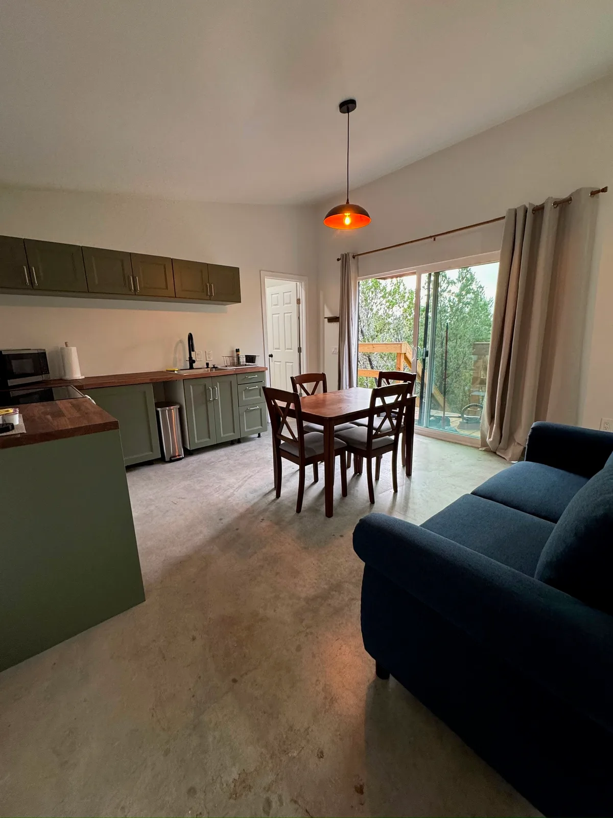 The open living space, with the dining table and the door out to the deck