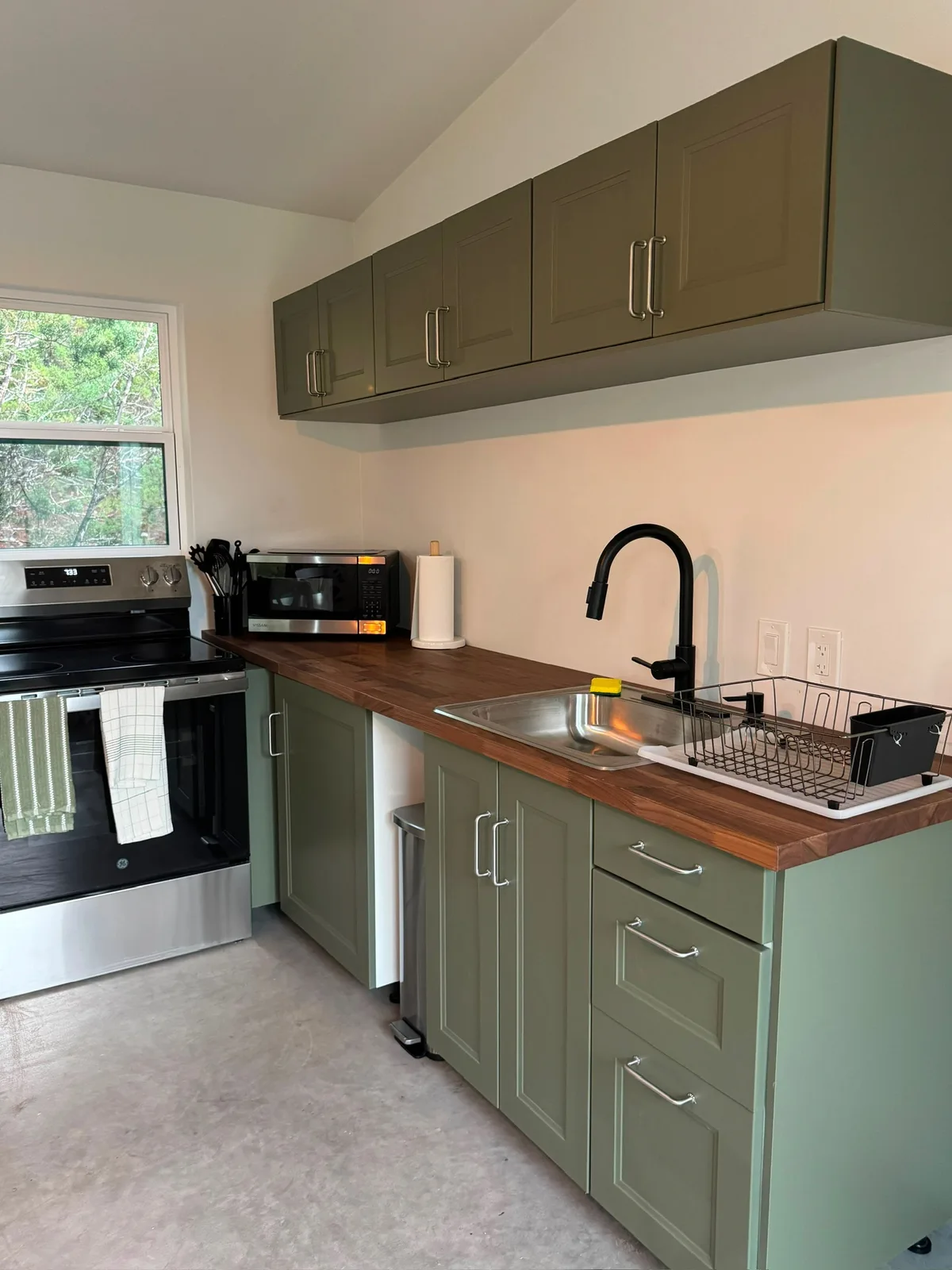 The kitchen, with olive-green cabinets and a butcher-block counter